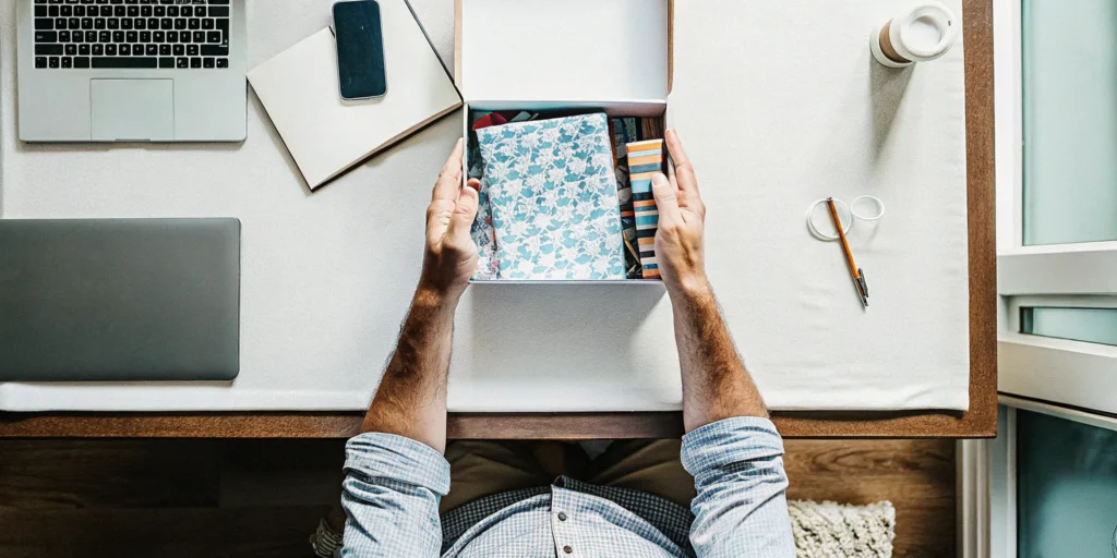 Remote employee opening a branded onboarding merchandise kit