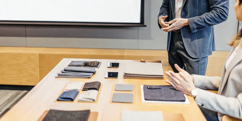 Enterprise merchandise professional reviewing branded product samples in a modern office meeting room
